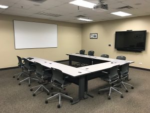 Meeting and collaborationroom with projection and flat panel and seating in a large U shape