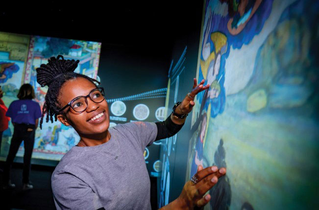 Woman interacting with large screen in Stein Luminary