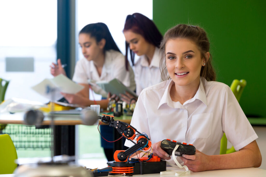 Female student with remote control for robot in her hand
