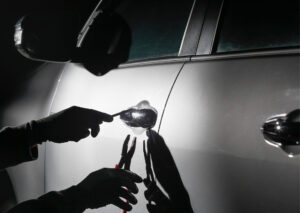 Someone breaking into cars with pliers and a screwdriver